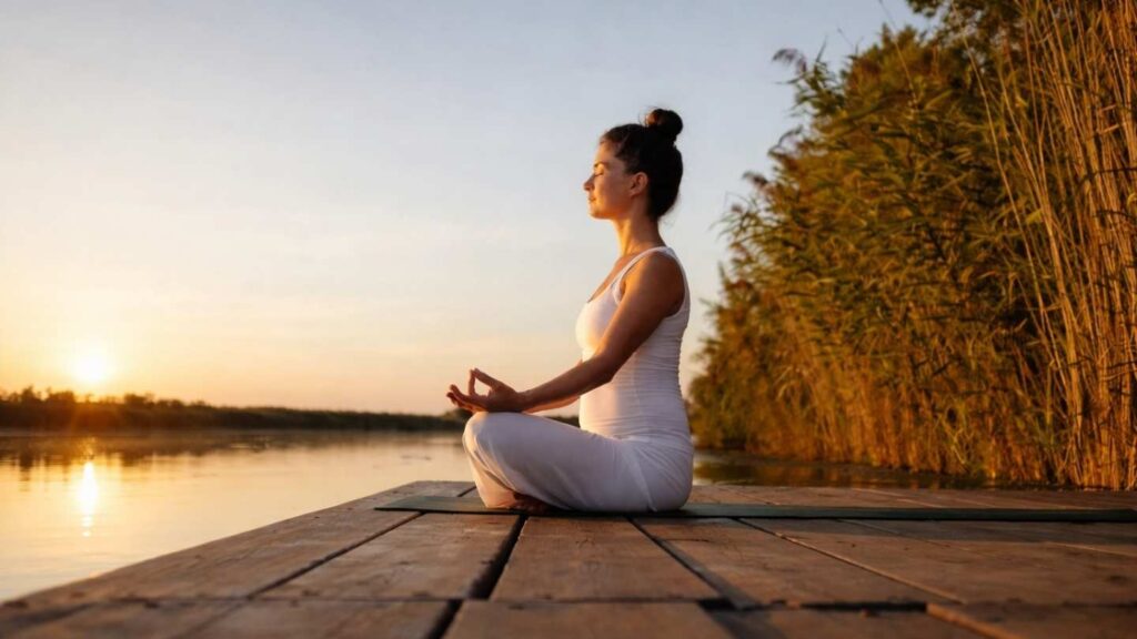 Woman meditating on a dock overlooking the ocean as part of holistic depression treatment