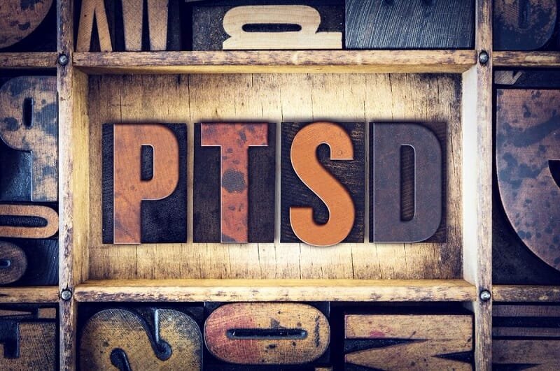 Wooden letterpress blocks spelling the word PTSD