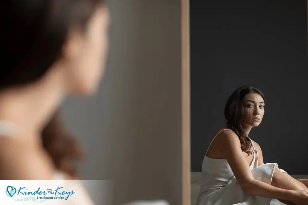 Woman looking depressed in mirror reflecting anxiety and PTSD