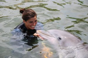 Benefits of dolphin therapy Woman interacting with dolphin