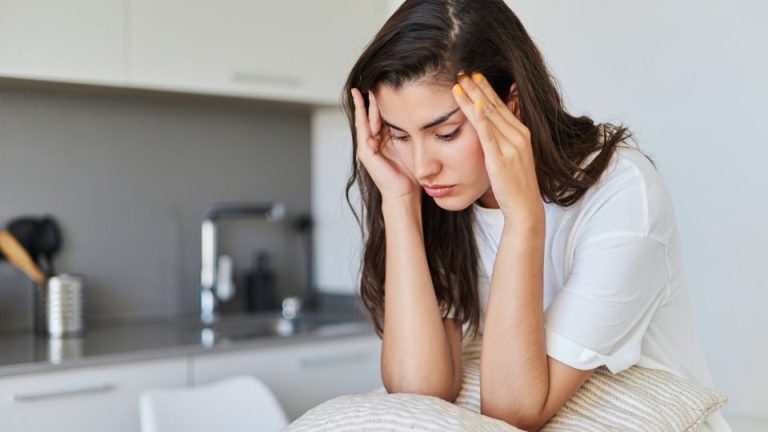 Common Depression Triggers and How to Manage Them hero image of a woman staring down.