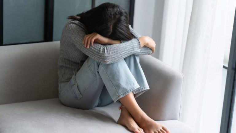 How to Break a Trauma Bond hero image of a woman with her head down.